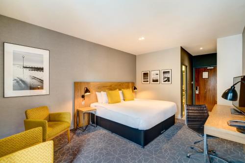 爱丁堡阿佩克斯跳蚤市场酒店的配有一张床和一张书桌的酒店客房