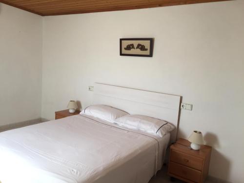 圣弗朗西斯科哈维尔Sa Figuera的卧室配有白色的床和2个床头柜