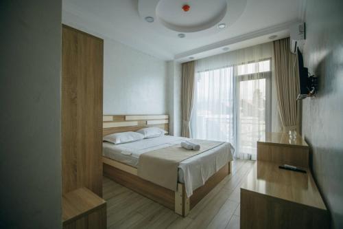巴统Hotel Batumi Palace的一间卧室设有一张床和一个大窗户