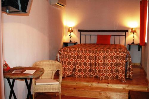 马尔旺Quinta Do Vaqueirinho - Agro-Turismo的卧室配有一张床和一张桌子及椅子