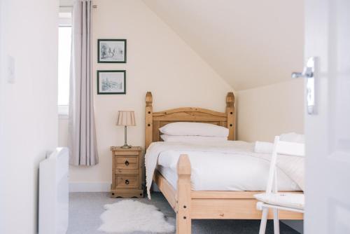 波特里Sea Shimmer的白色卧室配有木床和椅子