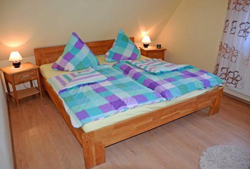 格洛韦Ferienreethaus mit Kamin und Sauna的一间卧室配有一张带紫色和蓝色棉被的床