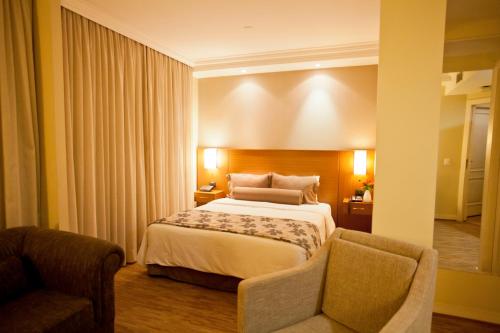 圣保罗The World Vila Olímpia的配有一张床和一把椅子的酒店客房