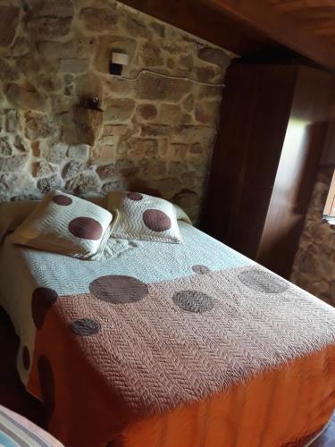 奥伦塞Loft Rural Corte de Fora的石墙房间内的一张床位