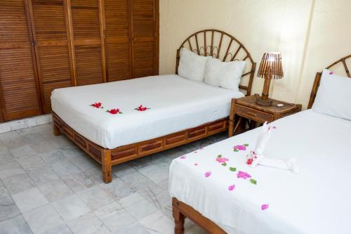 锡瓦塔塔内霍Villa Diamante的两张床铺,位于带鲜花的床单间
