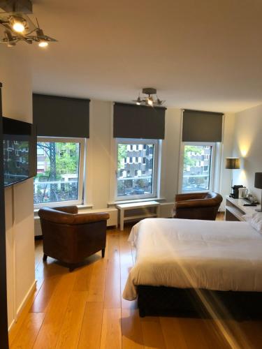 阿姆斯特丹布里奇住宿加早餐旅馆的一间卧室配有一张床、两把椅子和窗户