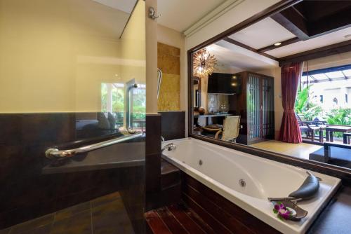 拉迈Samui Jasmine Resort - SHA Plus的一间带浴缸和大镜子的浴室