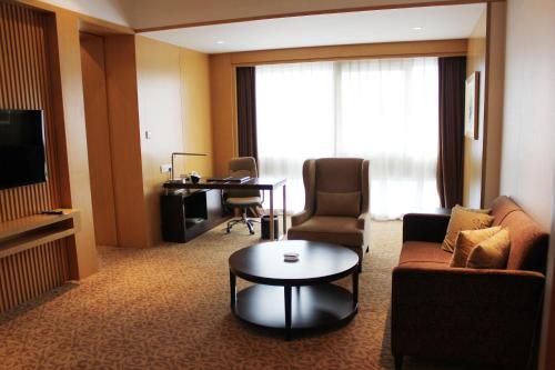 石家庄石家庄万象天成假日酒店的一间客厅,客厅配有沙发和一张桌子,位于酒店的房间