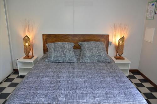 圣菲利普Le four à pain的一间卧室配有一张带枕头的床和两盏灯。