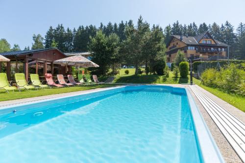 伏尔塔瓦河畔利普诺Hotel SLUNEČNÁ LOUKA的一座带房子的游泳池