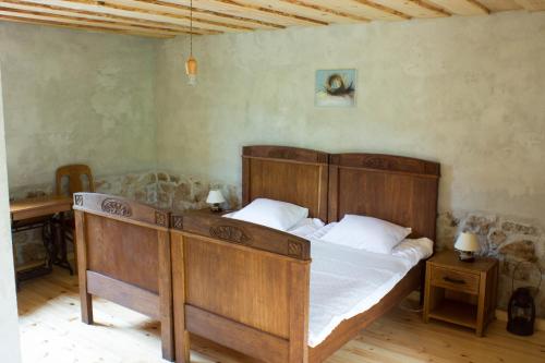 ĶegumsLauku māja "Zvejnieki"的一间卧室配有一张大木床和白色床单