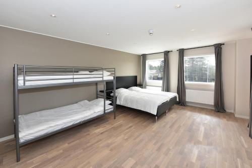 阿兰达Måby Park & Hotell的一间卧室设有两张双层床,铺有木地板。