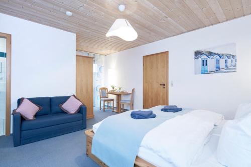FabrikschleichachZur Glashütte的一间卧室配有一张床和一张蓝色的沙发
