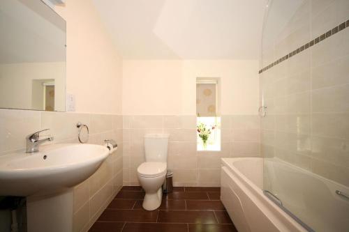 Ballyorgan贝利豪拉度假屋的浴室配有盥洗盆、卫生间和浴缸。