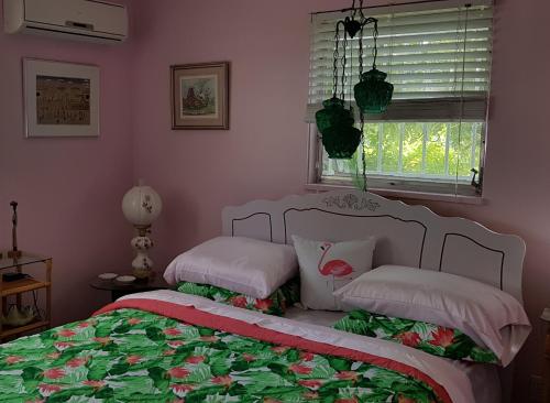 自由港市Bajamar Your Second Home Guest Property的一间卧室配有带两个枕头的床和窗户