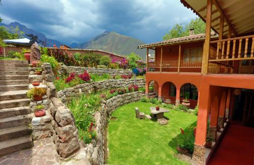 乌鲁班巴Luna Rumi Hotel-Lodge Urubamba的一座带石墙和房屋的花园