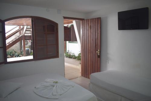 卡波布里奥普萨达威博酒店的一间卧室设有一张床、一个窗口和一台电视