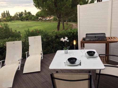 拉格朗德默特Le Birdy, terrasse, wifi, vélos, Clim的木制甲板上的白色桌子和椅子