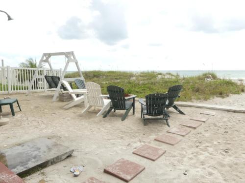克利尔沃特桑德格洛别墅的海滩上的一组椅子和一张桌子
