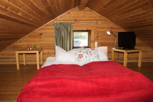 ZislowFerienhaus am Zylinderberg的小木屋内一间卧室配有红色的床