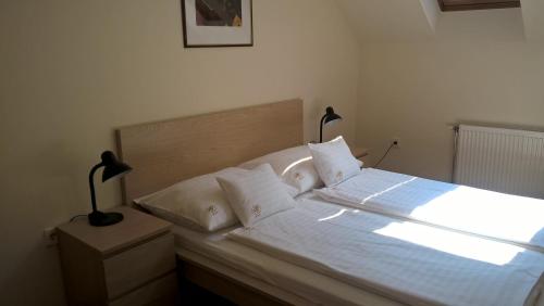 TolnaHotel Thelena的一间卧室配有带白色床单和枕头的床。