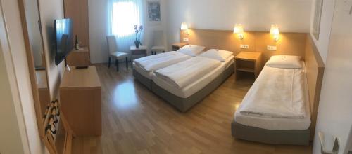 莱茵河畔的宾根幸福酒店的酒店客房设有两张床和电视。