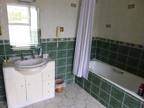 弗莫伊科比特苑酒店的绿色瓷砖浴室设有水槽和浴缸