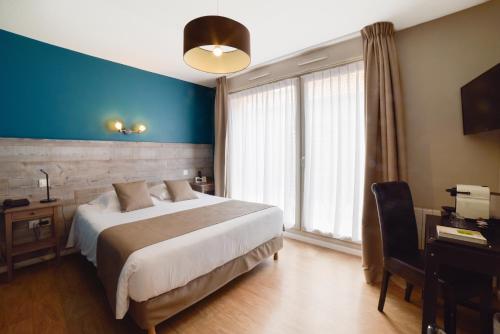 维桑Hôtel de la Baie de Wissant的一间卧室设有一张大床和蓝色的墙壁
