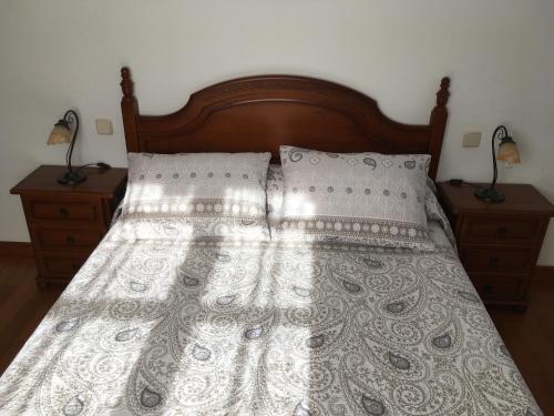 苏加拉穆尔迪Bizentenea的一张带白色床罩和2晚台架的床