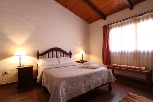 麦马拉Posta del Sol的一间卧室配有一张带两盏灯的床和一扇窗户。