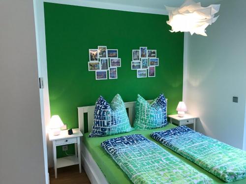 德累斯顿Louisenstraße 31的一间卧室设有绿色的墙壁和一张带枕头的床
