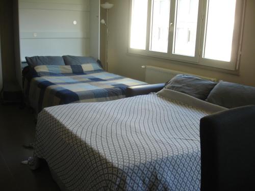 巴约讷Studio Centre Ville Office De Tourisme的客房设有两张床、一张沙发和一个窗口。