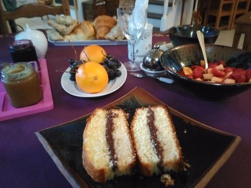Saint-Mars-la-Jaille阿皮斯特客房旅馆的一张桌子,上面放着一盘蛋糕和一碗水果