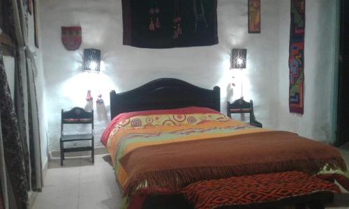 普尔马马尔卡Wara Wara的卧室配有一张床,墙上挂着两盏灯