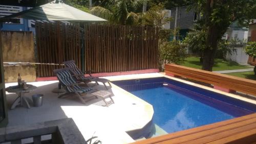 鲍巴Casa em Toque Toque Pequeno的一个带两把椅子的庭院和一个游泳池