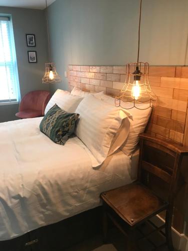 普尔赫利Rooms at Martha Jones的卧室配有一张白色大床和两个灯