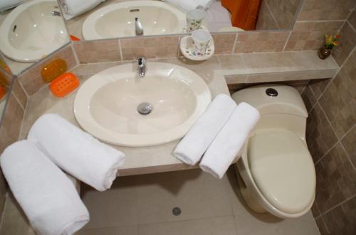 伊察Jazmines Lodging的浴室配有盥洗盆和带毛巾的卫生间。