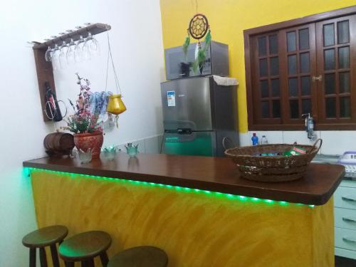 伊利亚贝拉Flat Filtro Dos Sonhos的厨房配有带凳子的柜台和冰箱。