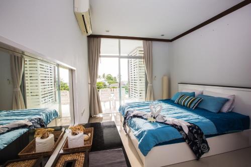 功孟海滩At Seacondo-2 Bedrooms-B35的一间卧室设有两张床和大窗户