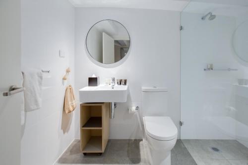 悉尼尾流百老汇公寓酒店的白色的浴室设有卫生间和镜子