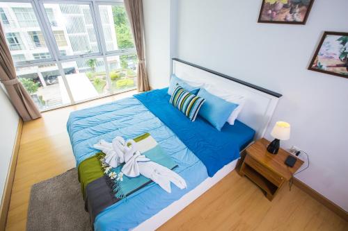 功孟海滩At Seacondo-1 Bedroom-A20的一间卧室配有一张大床,提供蓝色的床单和枕头