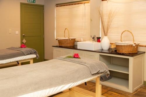 巴拉克拉瓦旅人蕉风姿酒店的一间医院间,配有两张床和盥洗盆
