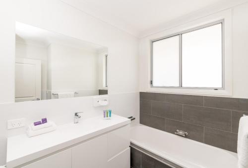 纽卡斯尔Wallsend on Longworth的白色的浴室设有水槽和镜子