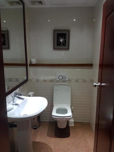 基加利遗产大酒店的一间带水槽、卫生间和镜子的浴室