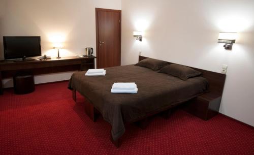哈尔科夫12酒店的一间卧室配有一张床,上面有两条毛巾