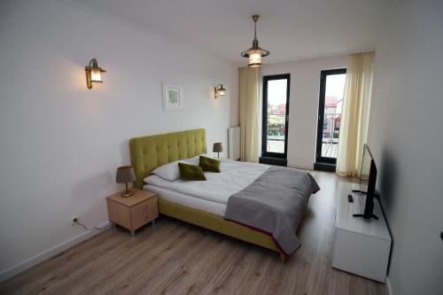 达洛科Apartamenty Przy Latarni Kropla Bałtyku的一间卧室配有一张床和一台电视