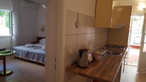 察夫塔特Guest House Sol的一个带水槽的厨房和一张位于客房内的床