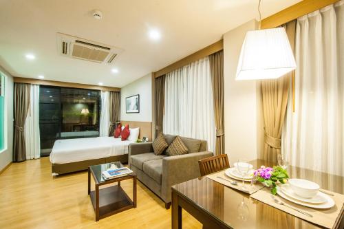 Si Maha PhotBurgundy Residence 304的酒店客房设有床和客厅。
