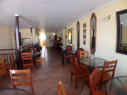 CombarbaláInti Hotel的餐厅内带桌椅的用餐室