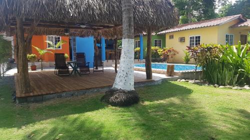 Puerto ArmuellesSunrise Inn的一座带棕榈树木甲板的房子